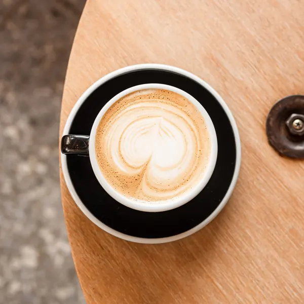 Latte art in a ceramic cup on a wooden table